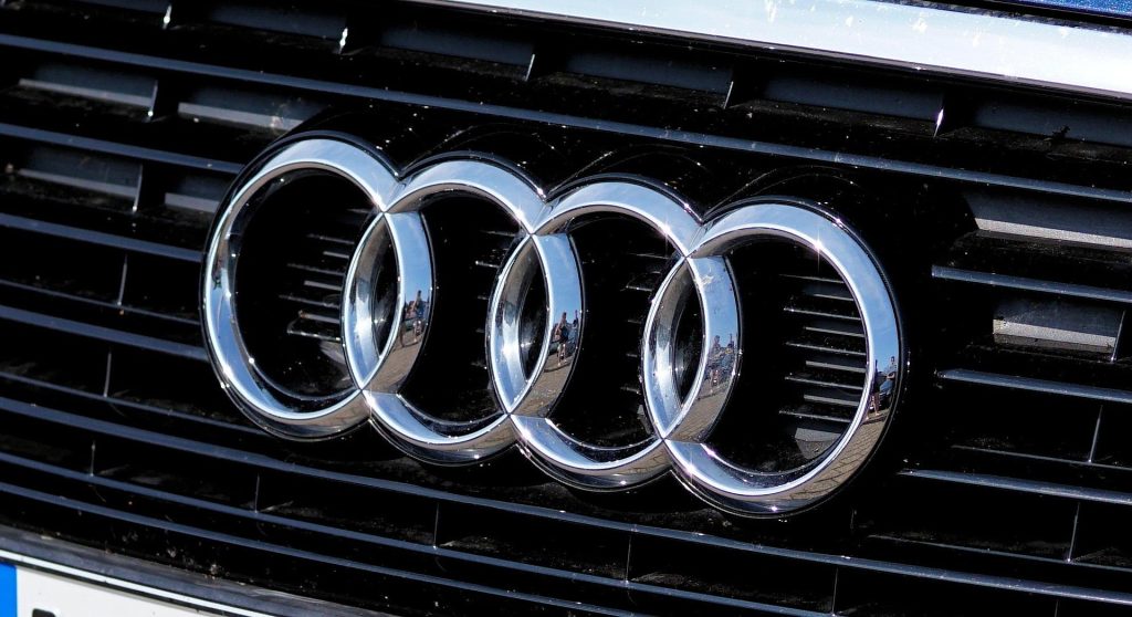 - Close-up of the Audi four-ring logo on the front grille of a car