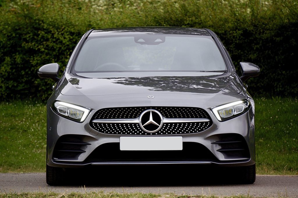 Front view of a grey Mercedes car parked outdoors with the Mercedes badge and grille visible